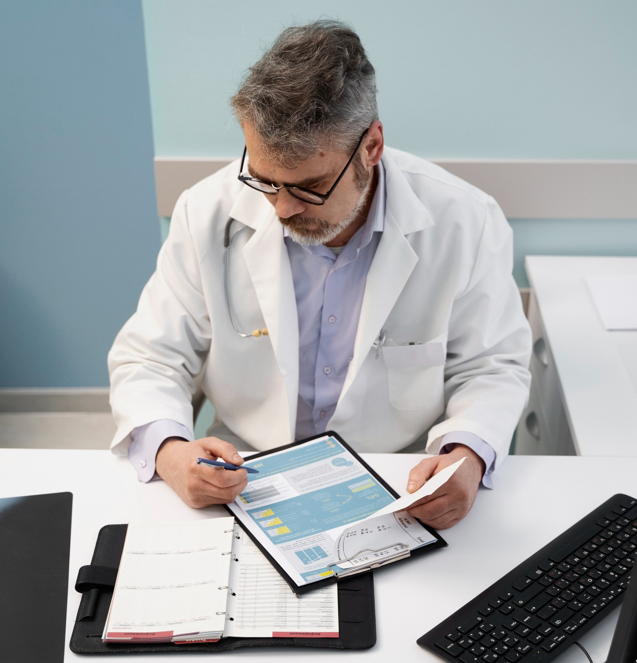 Senior doctor in a white coat reviewing printed patient reports at a desk