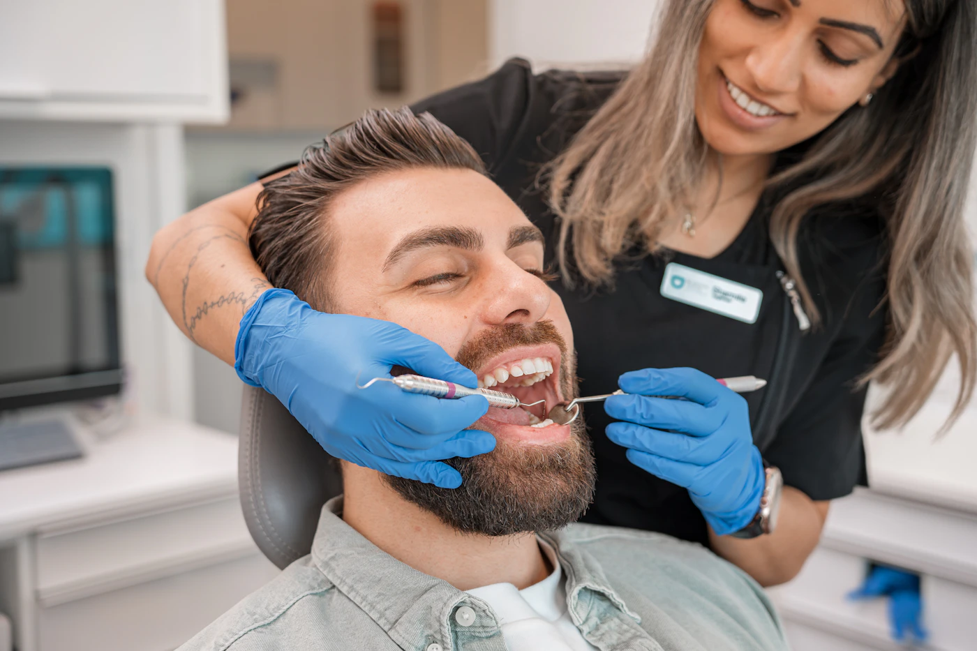 Dentist examining a smiling patient's teeth