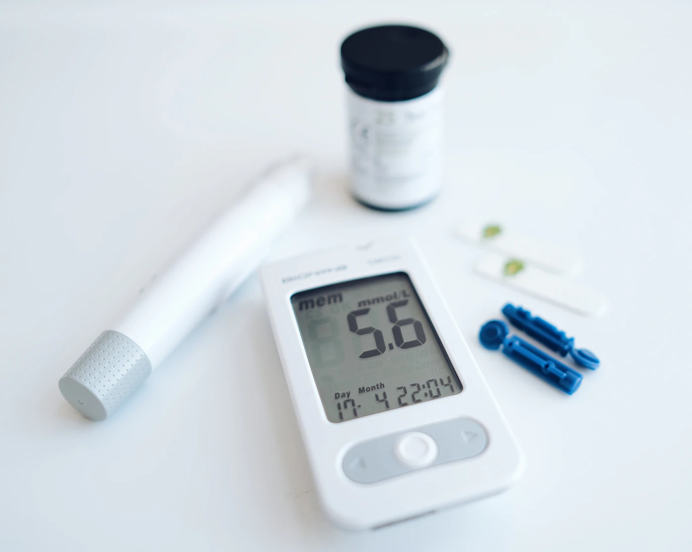 Blood glucose meter, lancing device and test strips on a white table
