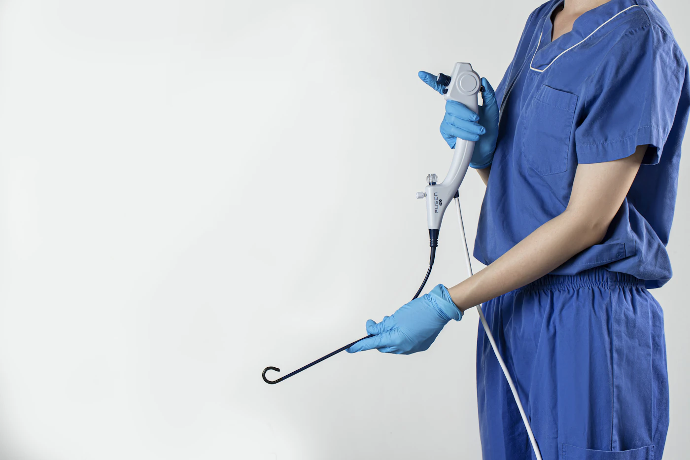 Clinician in scrubs holding a flexible endoscope