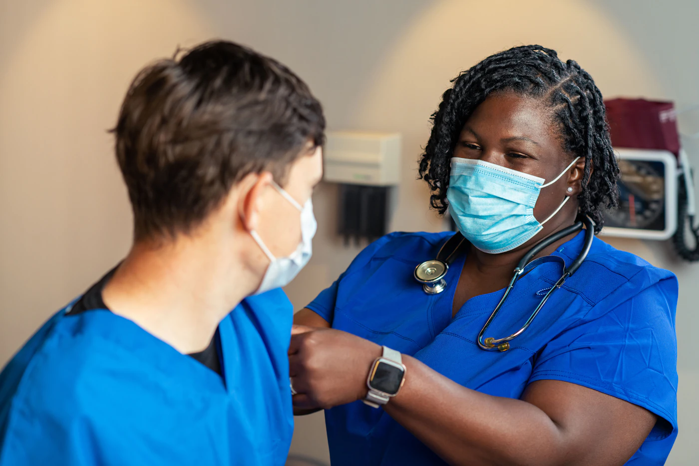Nurse in blue scrubs caring for a patient in the hospital