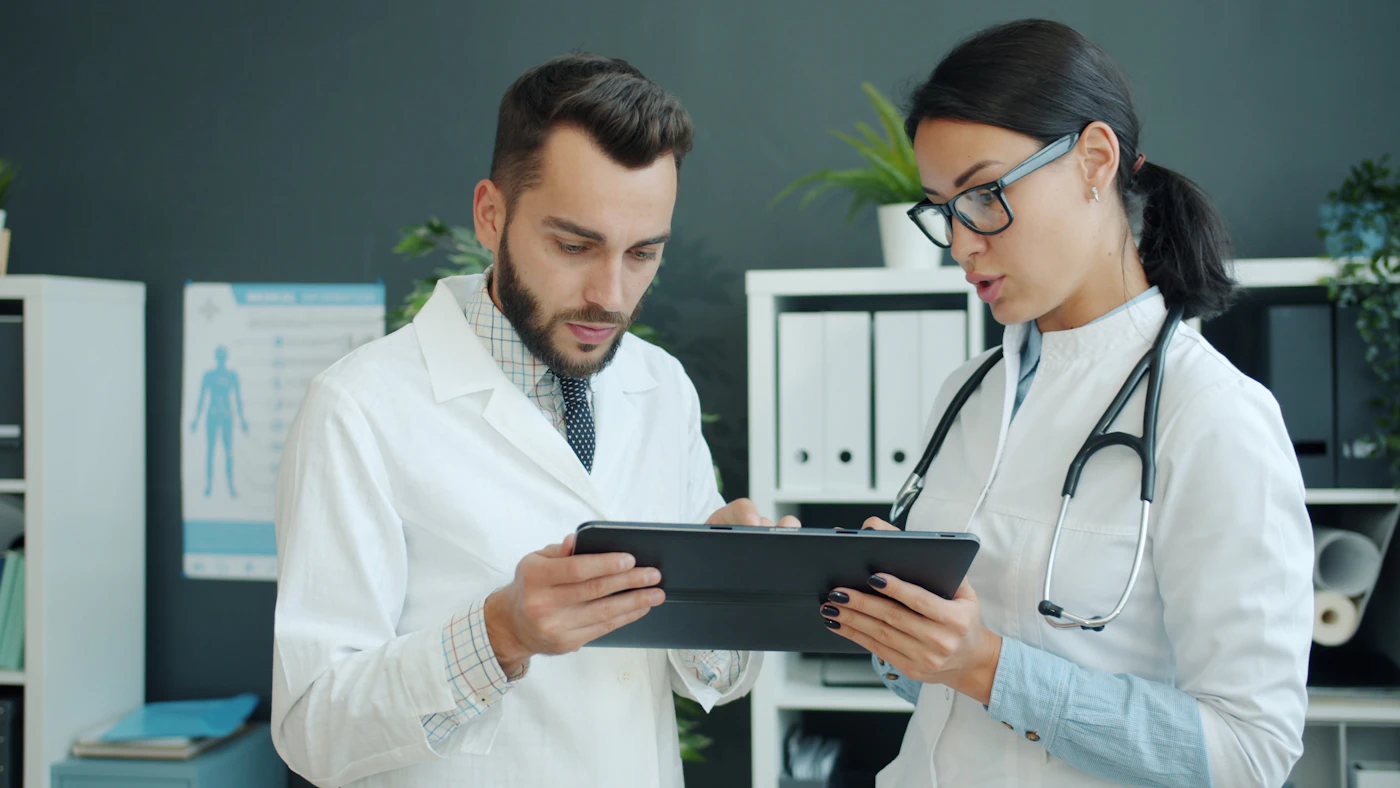 Two clinicians reviewing a patient's chart on a tablet together