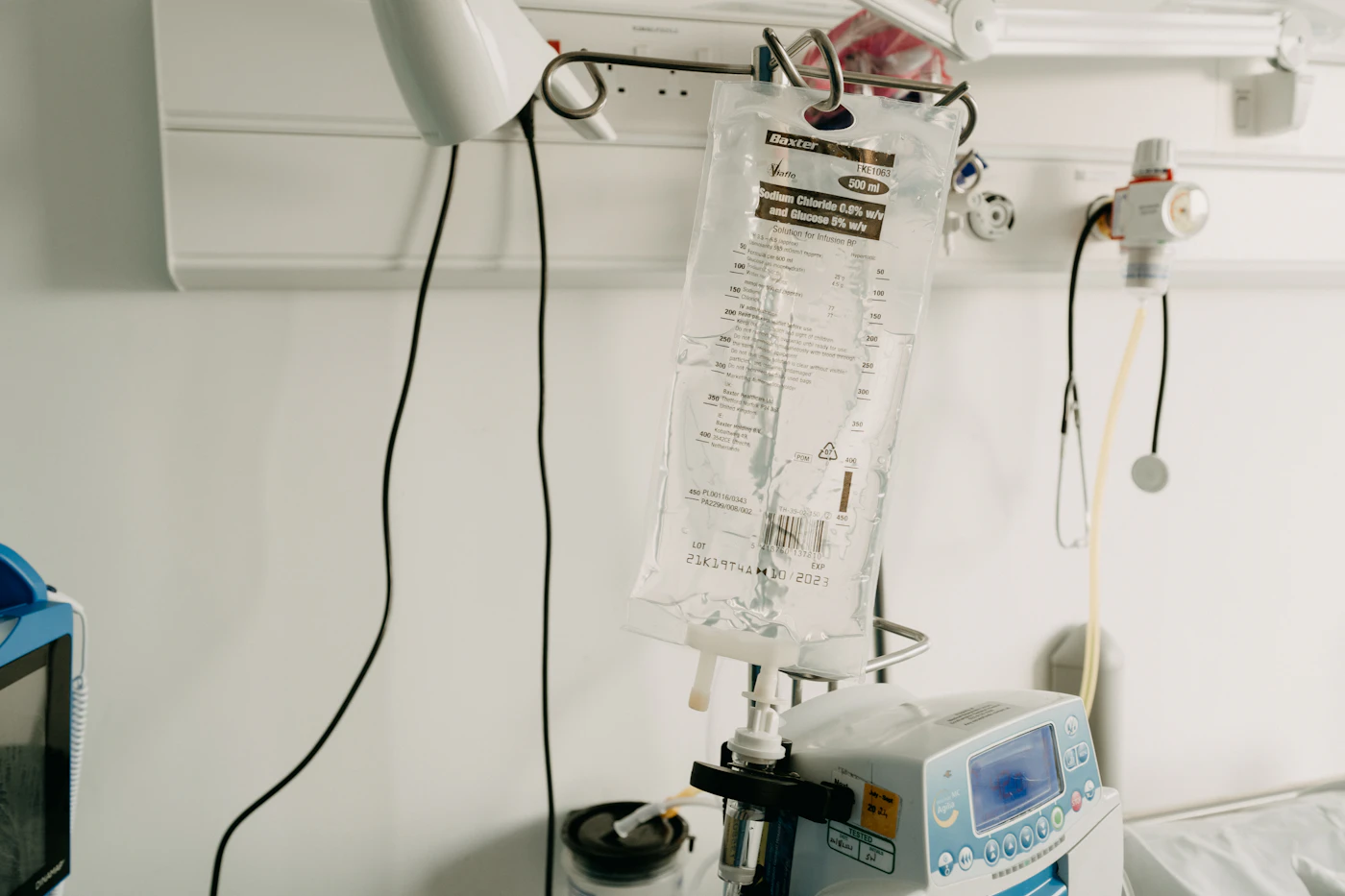 IV bag and infusion pump set up beside a hospital bed