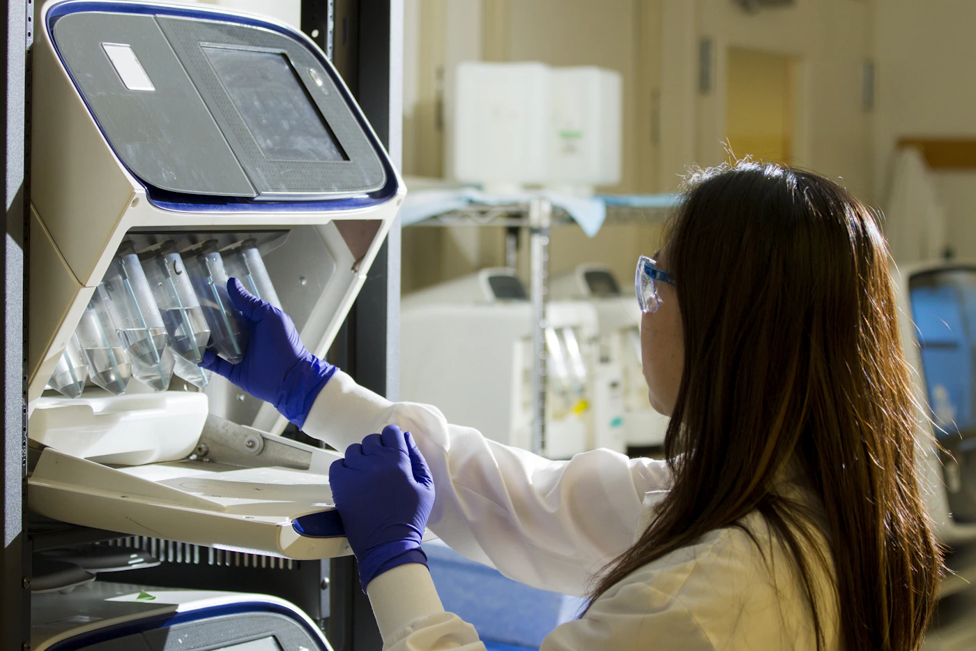 Laboratory technician loading sample tubes into an analyzer