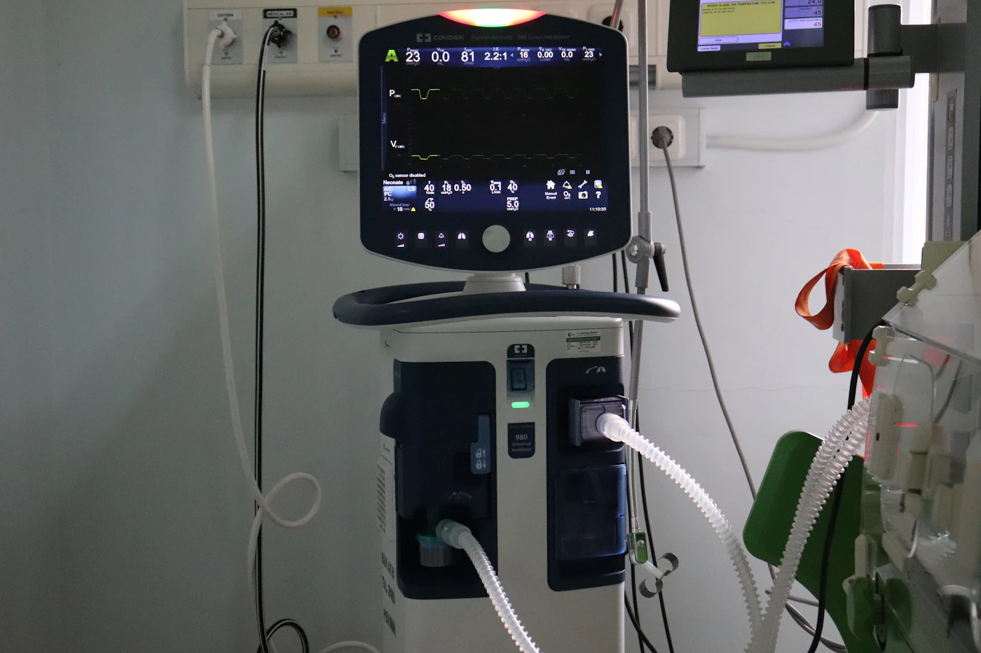 Treatment machine with a monitor and tubing beside a patient's bed