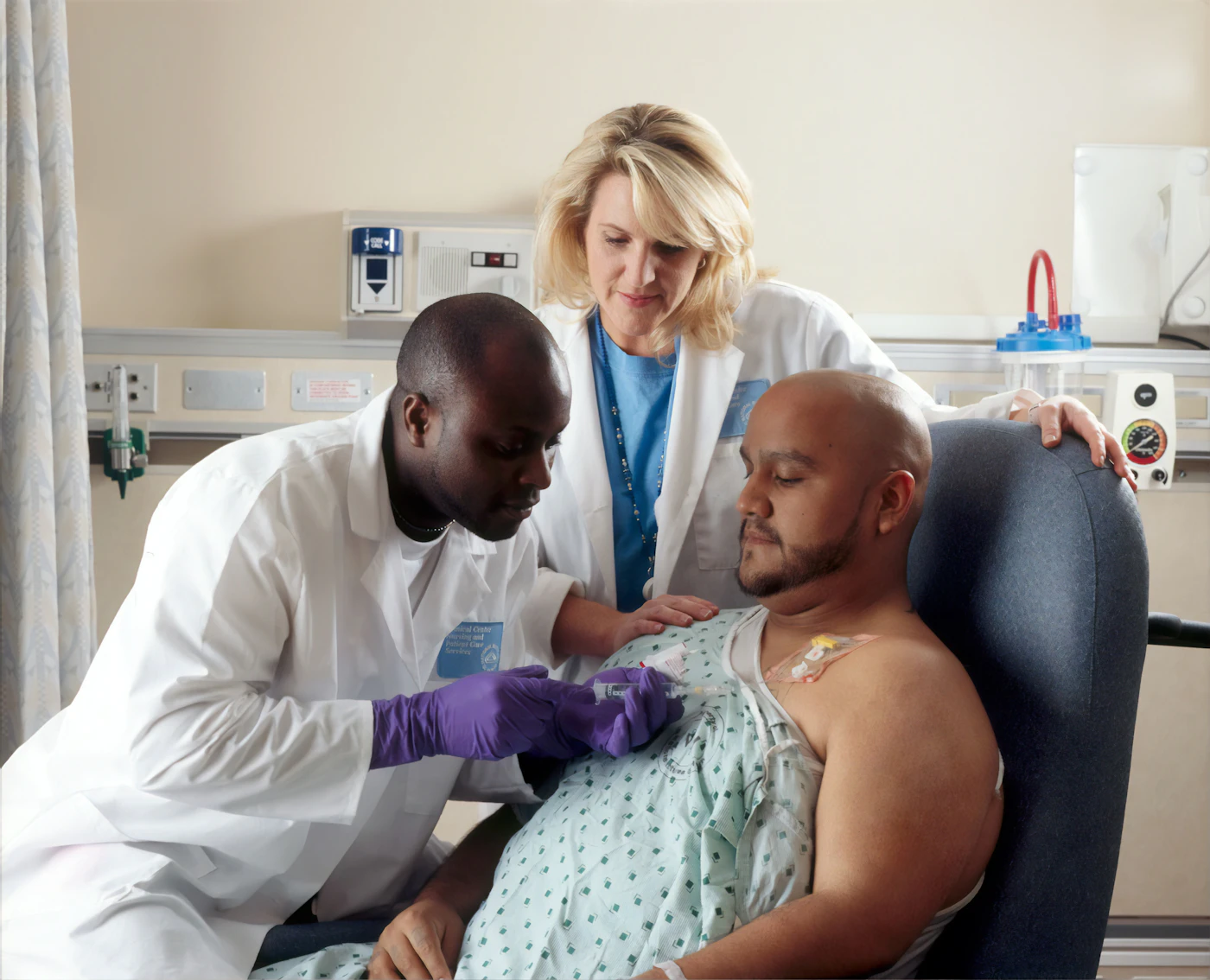 Clinicians caring for a patient seated in an infusion chair