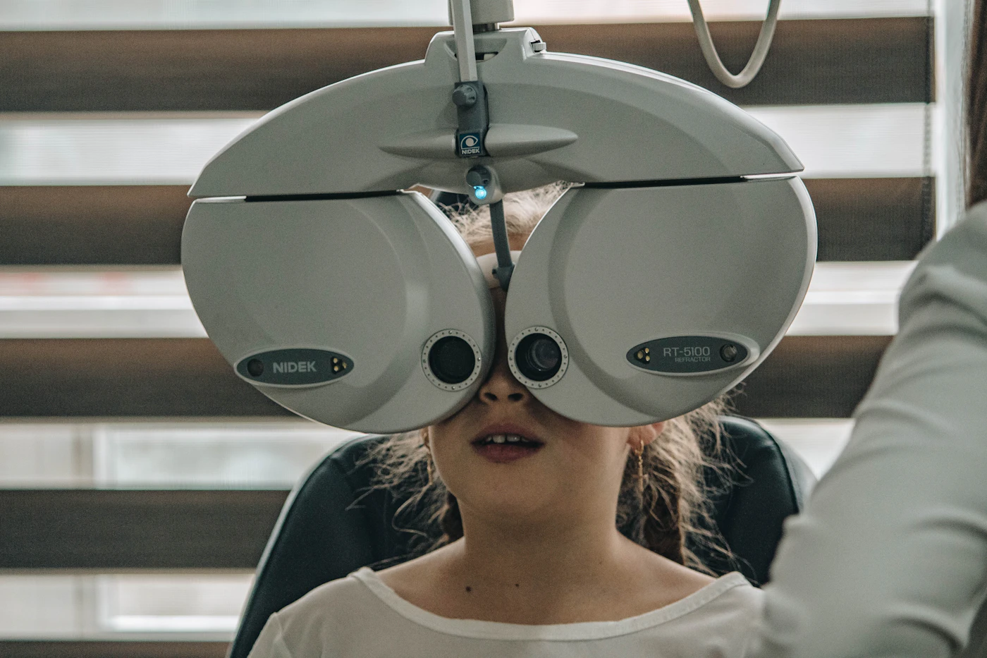 Patient looking into a phoropter during an eye exam