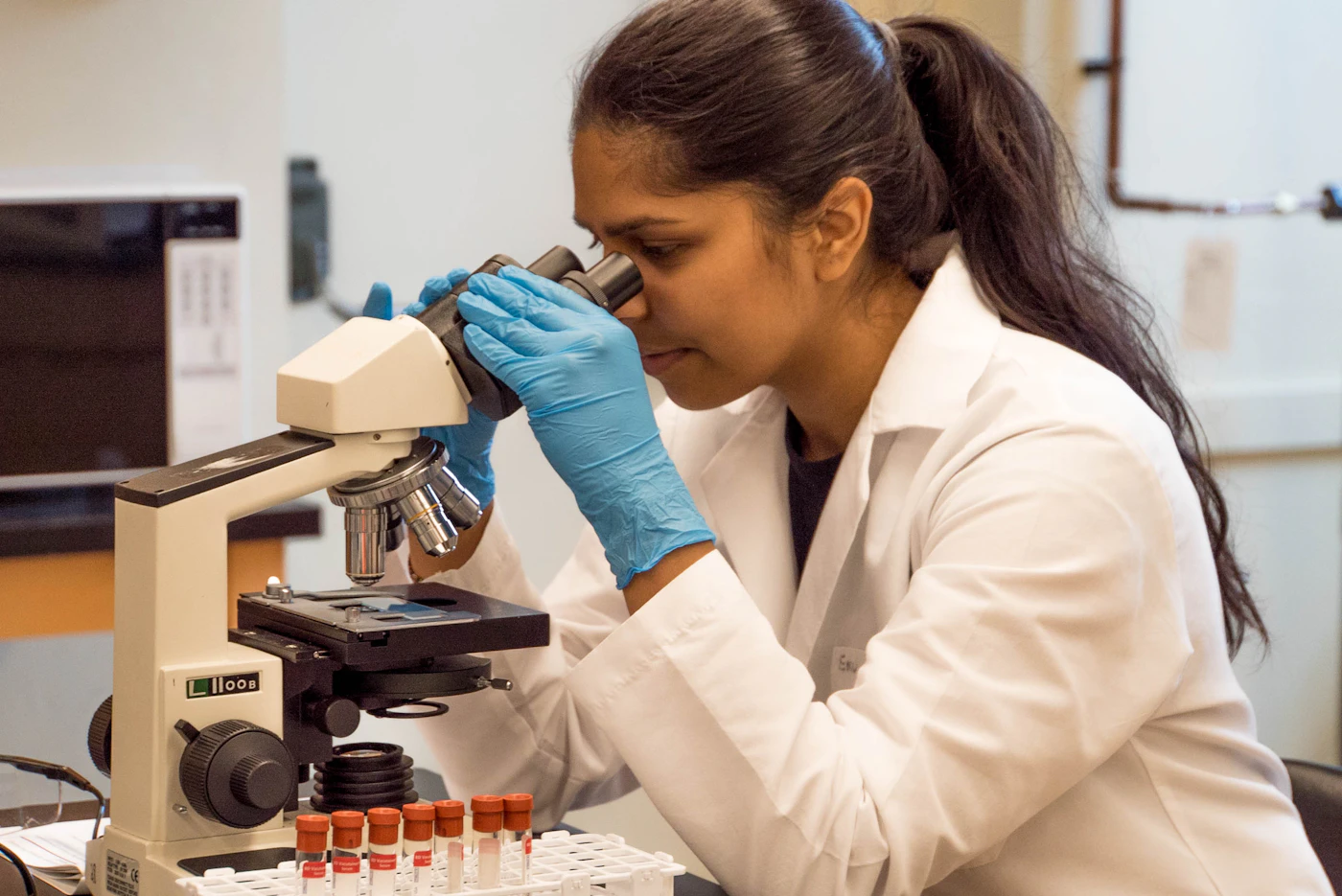Pathologist looking through a microscope in a laboratory