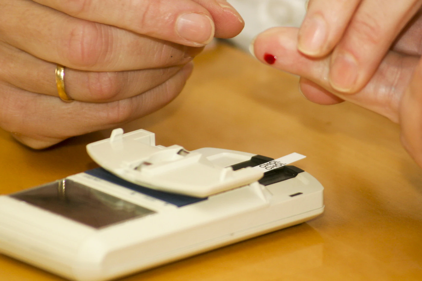Patient testing blood sugar with a finger-stick glucose meter