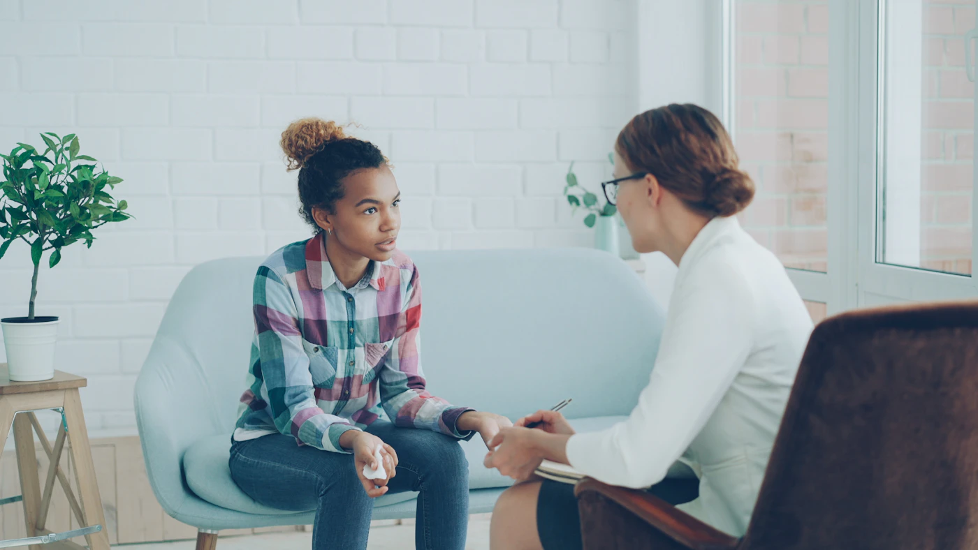 Clinician talking with a young woman during a psychiatric appointment