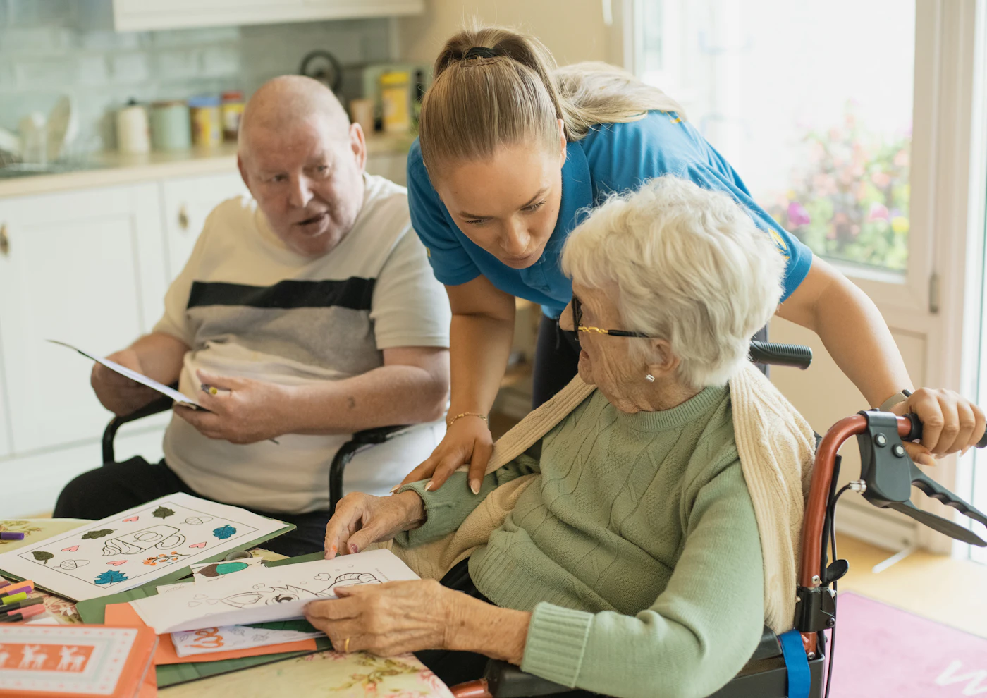 Therapist helping older adults with a hand activity at a table