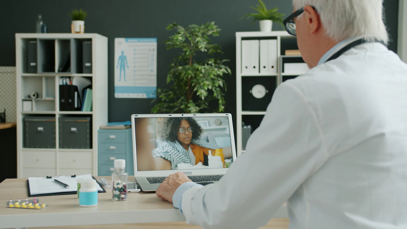 Physician meeting a patient by video call on a laptop