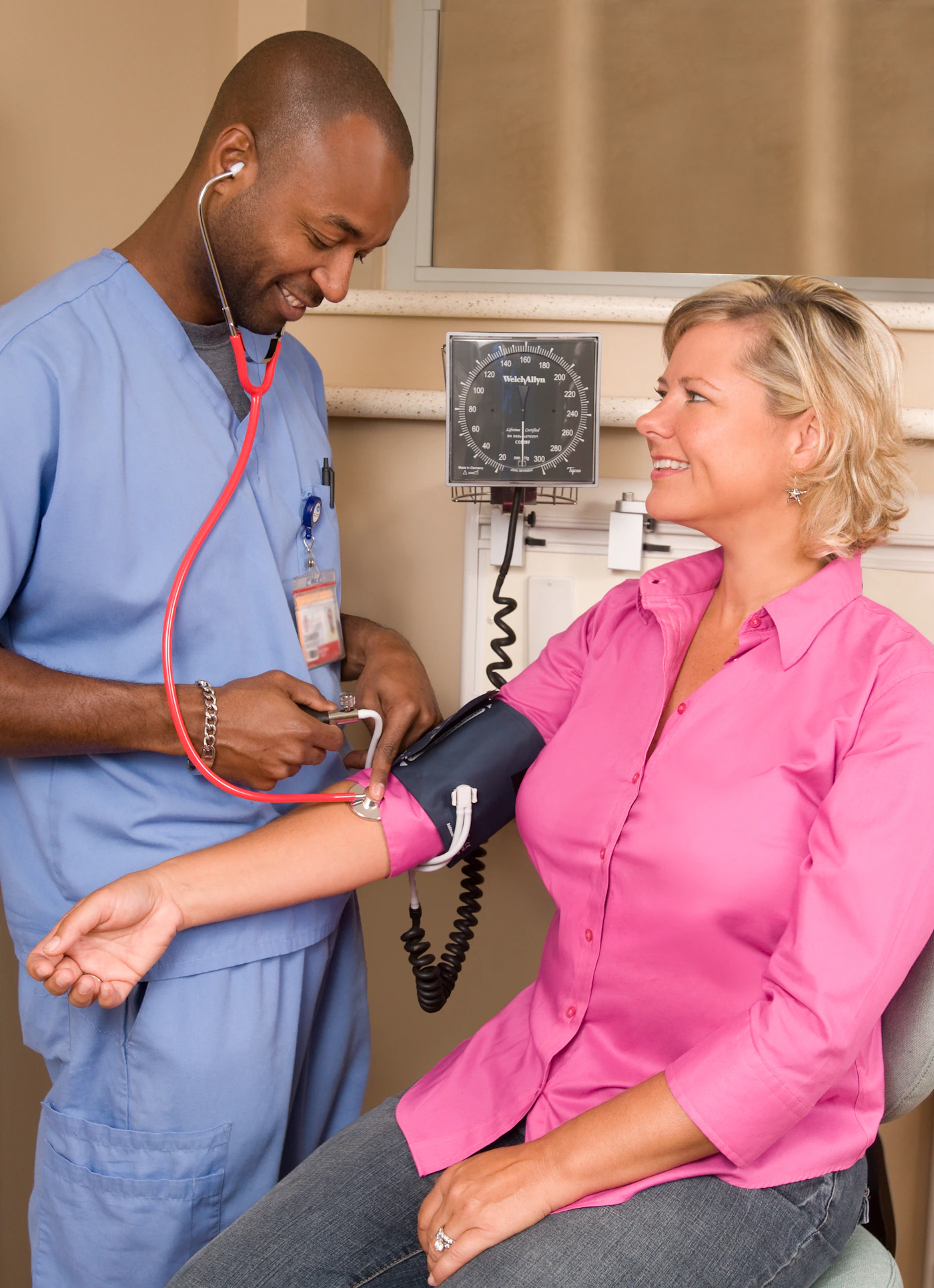 Clinician checking a patient's blood pressure in a walk-in clinic exam room